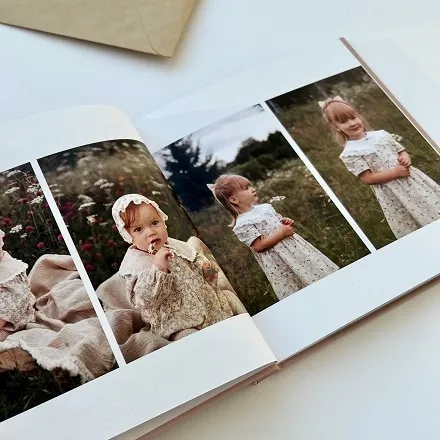 Разворот детской фотокниги с тремя фото девочки в кружевном платье на природе